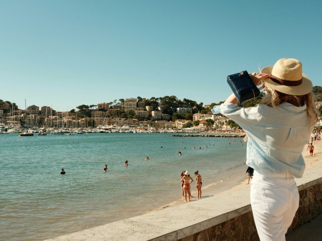 A photographer standing beside a bright blue beach
